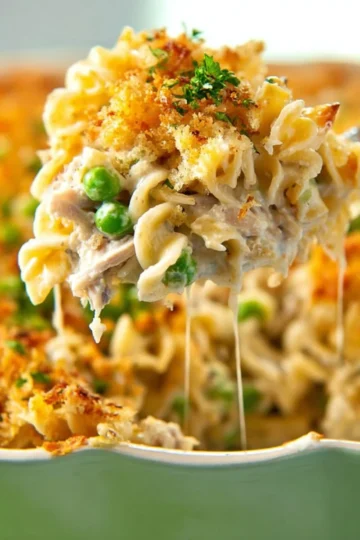 Delicious creamy tuna noodle casserole served in a dish with cheese topping