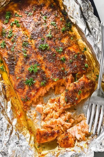 Baked salmon with maple mustard glaze on a white plate garnished with herbs