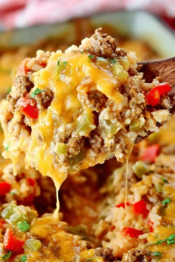 Delicious stuffed pepper casserole topped with melted cheese and fresh herbs