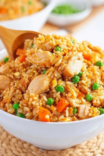 Delicious Chicken Fried Rice served in a bowl with vegetables and chicken pieces.