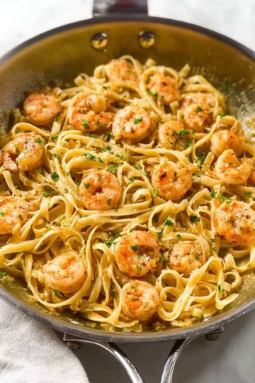 Creamy garlic shrimp pasta topped with fresh herbs and parmesan cheese.