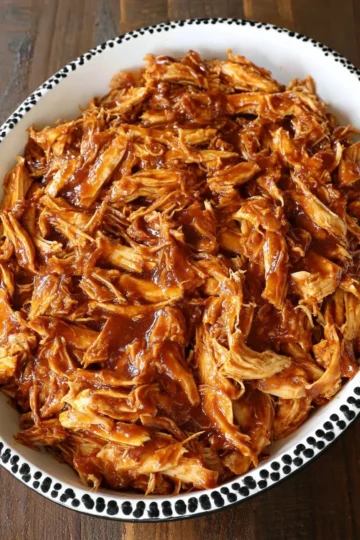 Crockpot BBQ Chicken served on a plate with barbecue sauce and sides