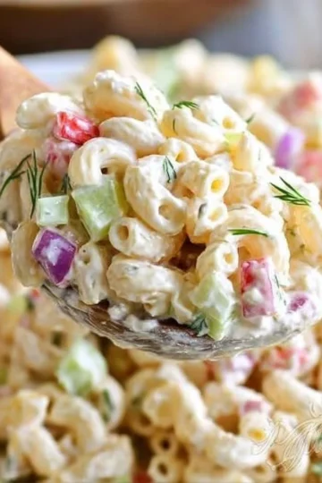 Creamy family favorite macaroni salad served in a bowl with vegetables