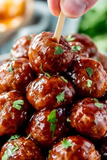 Delicious Honey BBQ Crockpot Meatballs served in a bowl with a drizzle of sauce.