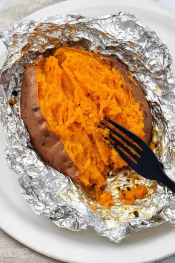 Baked sweet potatoes wrapped in foil, ready to enjoy a flavorful meal.