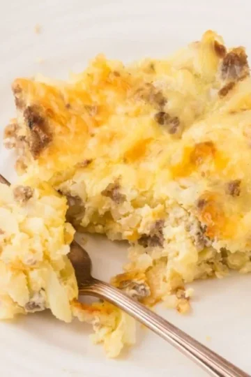 Sausage breakfast casserole served on a plate with fresh herbs