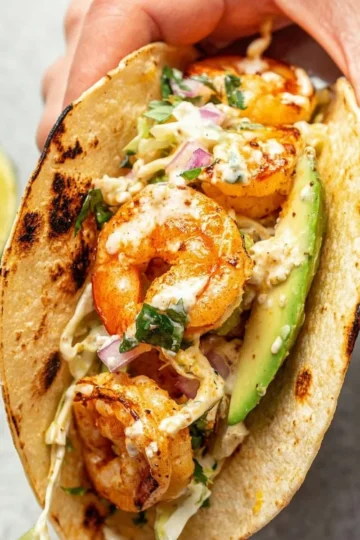 Plate of flavorful shrimp tacos garnished with fresh ingredients