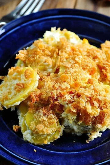 Creamy squash casserole baked with cheese and breadcrumbs, garnished with herbs