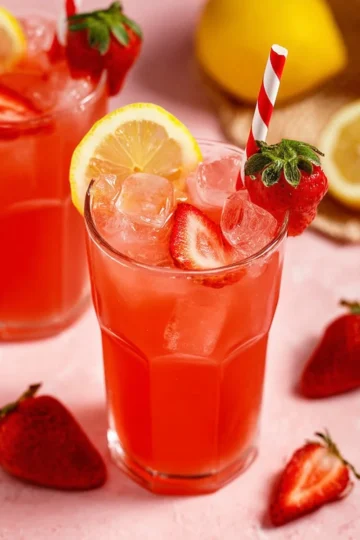 A refreshing glass of homemade strawberry lemonade with fresh strawberries.
