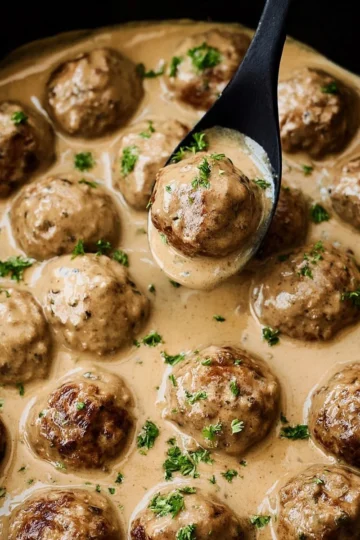 Plate of authentic Swedish Meatballs with creamy sauce and parsley garnish
