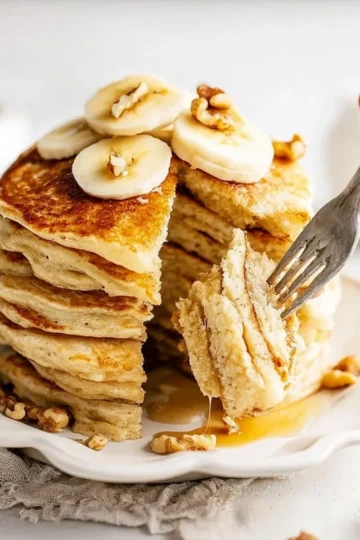 Three ingredient banana pancakes stacked on a plate with syrup