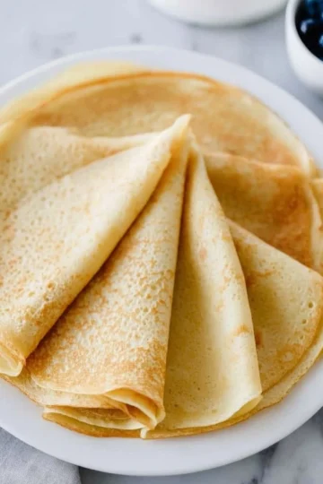 Delicious homemade crepes served with fruit and syrup