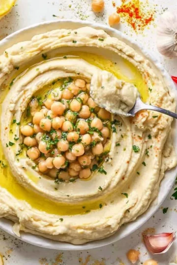 Bowl of the best hummus recipe topped with olive oil and paprika.