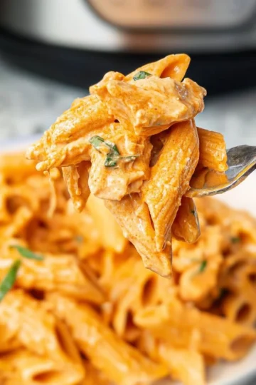 Delicious Buffalo Chicken Pasta topped with cheese and garnished with parsley.