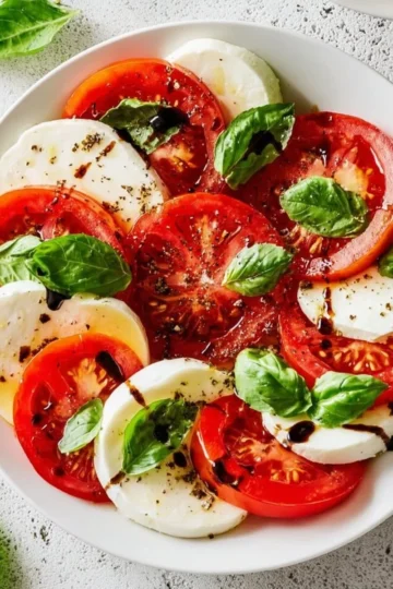 A delicious Caprese Salad with fresh tomatoes, mozzarella, and basil leaves