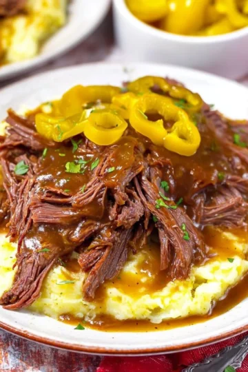 Delicious Crockpot Mississippi Pot Roast garnished with herbs and served on a plate