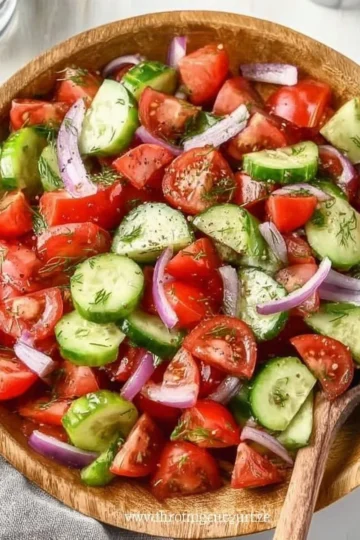 Fresh Cucumber Tomato Salad with herbs and dressing in a bowl