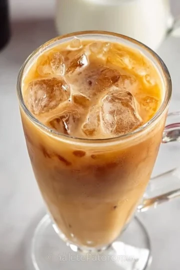 Delicious homemade iced coffee in a glass with ice cubes and a straw.