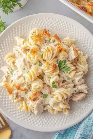 Garlic Parmesan Chicken Pasta Bake served in a white dish with fresh herbs