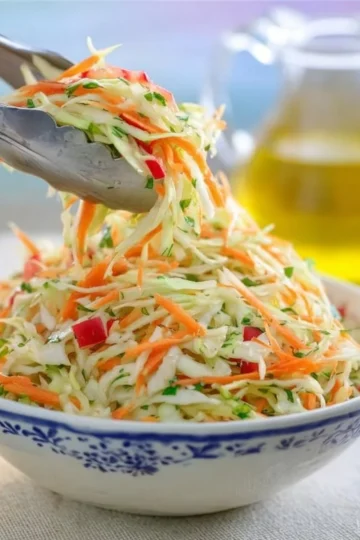 Bowl of healthy cabbage salad with fresh vegetables and dressing