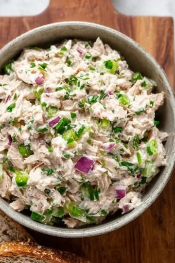 Healthy tuna salad in a bowl with fresh vegetables and herbs