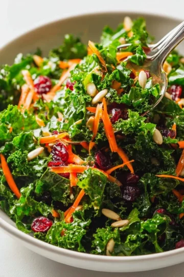 Delicious kale salad with lemon vinaigrette dressing on a wooden table