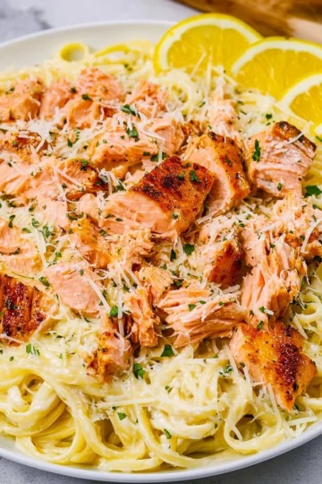 Delicious salmon pasta with lemon cream sauce garnished with herbs