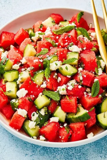 Watermelon salad with feta cheese, cucumber, and fresh mint garnished on a plate