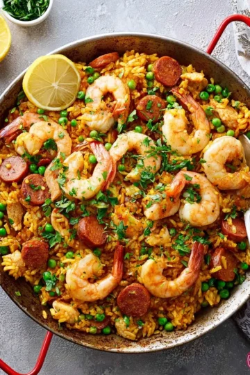 Delicious easy paella served in a traditional pan with seafood and vegetables.