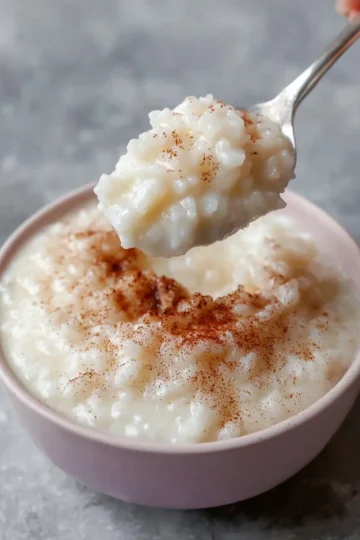 Bowl of easy homemade rice pudding topped with cinnamon and raisins