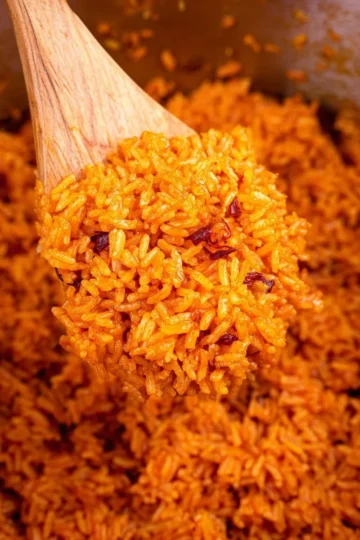 Delicious serving of Jollof Rice garnished with vegetables and spices