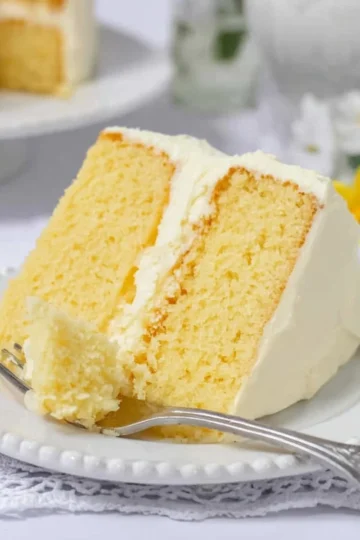 Lemon Velvet Cake topped with creamy frosting on a decorative plate