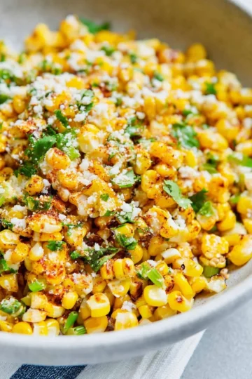 Mexican Street Corn off the cob served in a bowl with toppings.