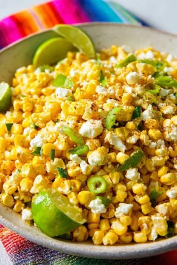 Colorful Mexican street corn salad topped with cheese and spices