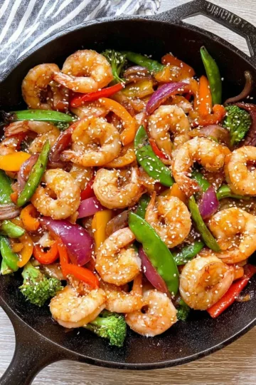 Colorful shrimp stir fry with vegetables in a pan.