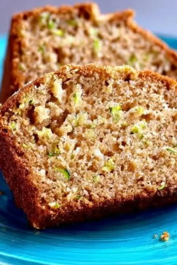 Loaf of classic zucchini bread with slices cut on a wooden board