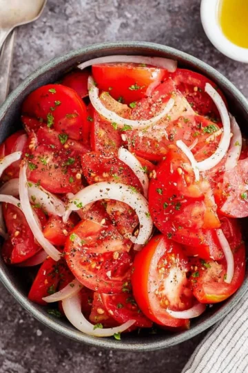 A vibrant tomato onion salad with fresh ingredients in a bowl.