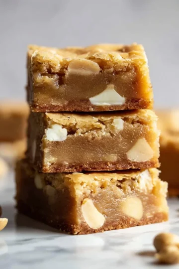 Delicious white chocolate blondies served on a plate with a drizzle of white chocolate.
